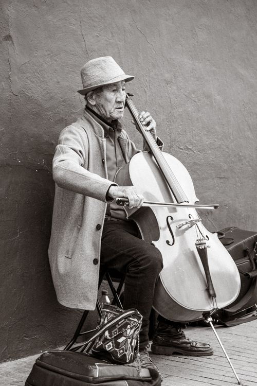 Free Elderly musician playing cello on Bogotá street, evoking nostalgia. Stock Photo