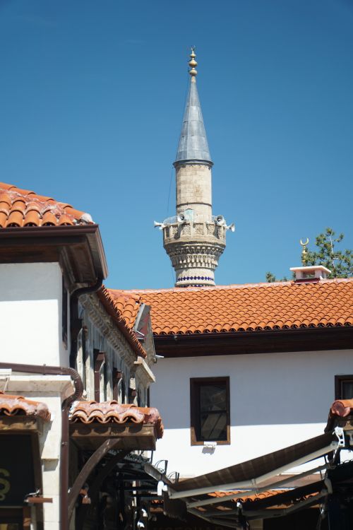 Free Charming traditional architecture with a prominent minaret in Isparta, Türkiye under a clear blue sky. Stock Photo