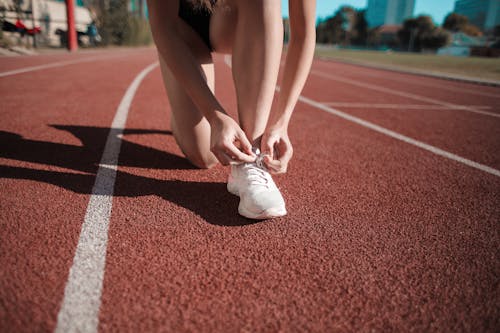 Close Up Foto Van Vrouw Haar Witte Sneakers Binden Op Atletiekbaan