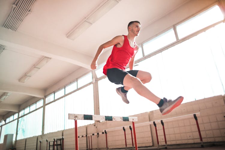 Woman In Red Tank Top Jumping On Obstacle