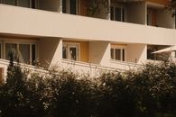 Sunny view of a modern apartment building with shrubs in Lahti, Finland.