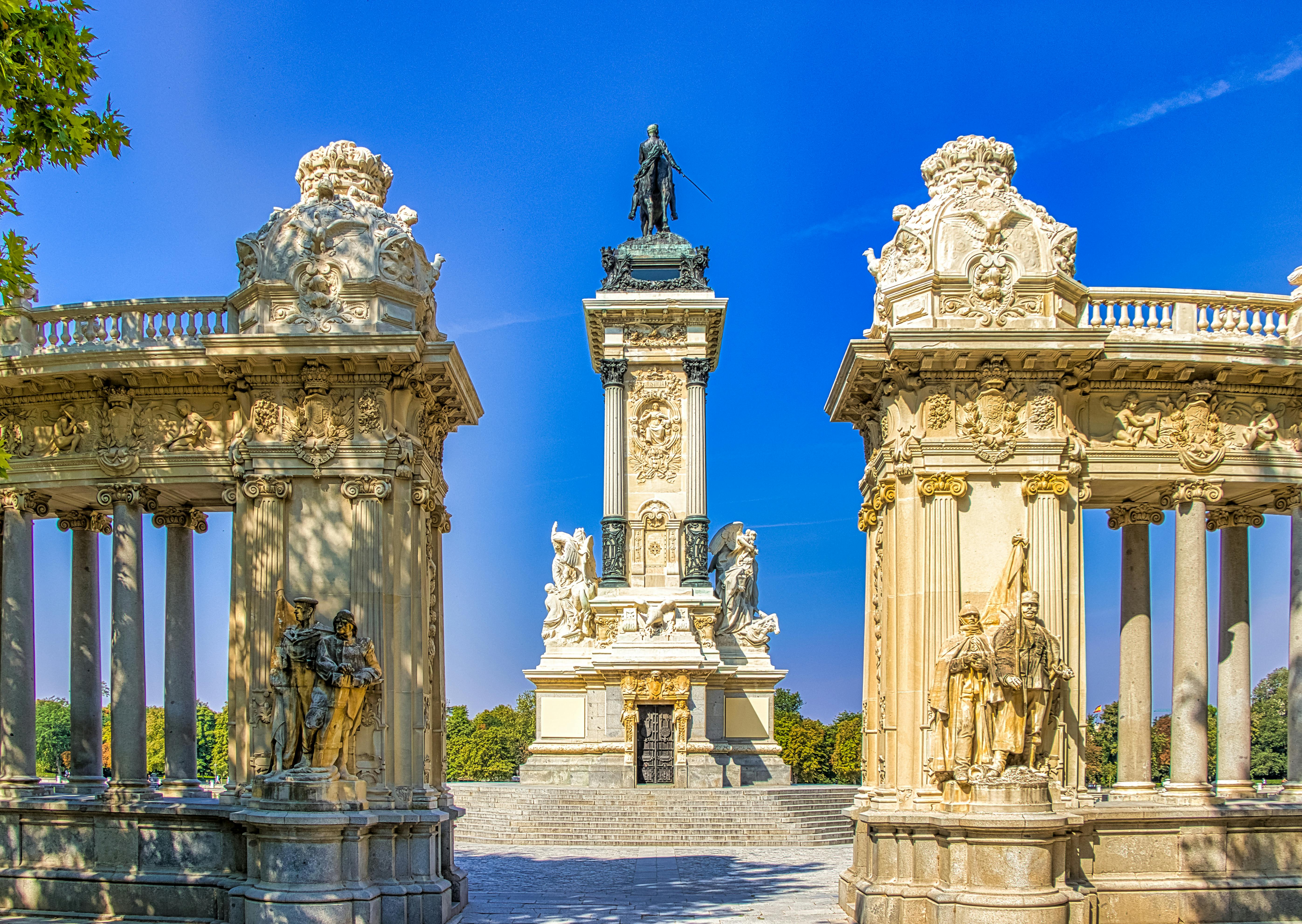 white and black concrete statues under blue sky