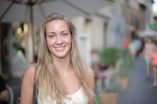 光天化日之下，一名年轻的金发女子在热闹的城市街道上微笑着