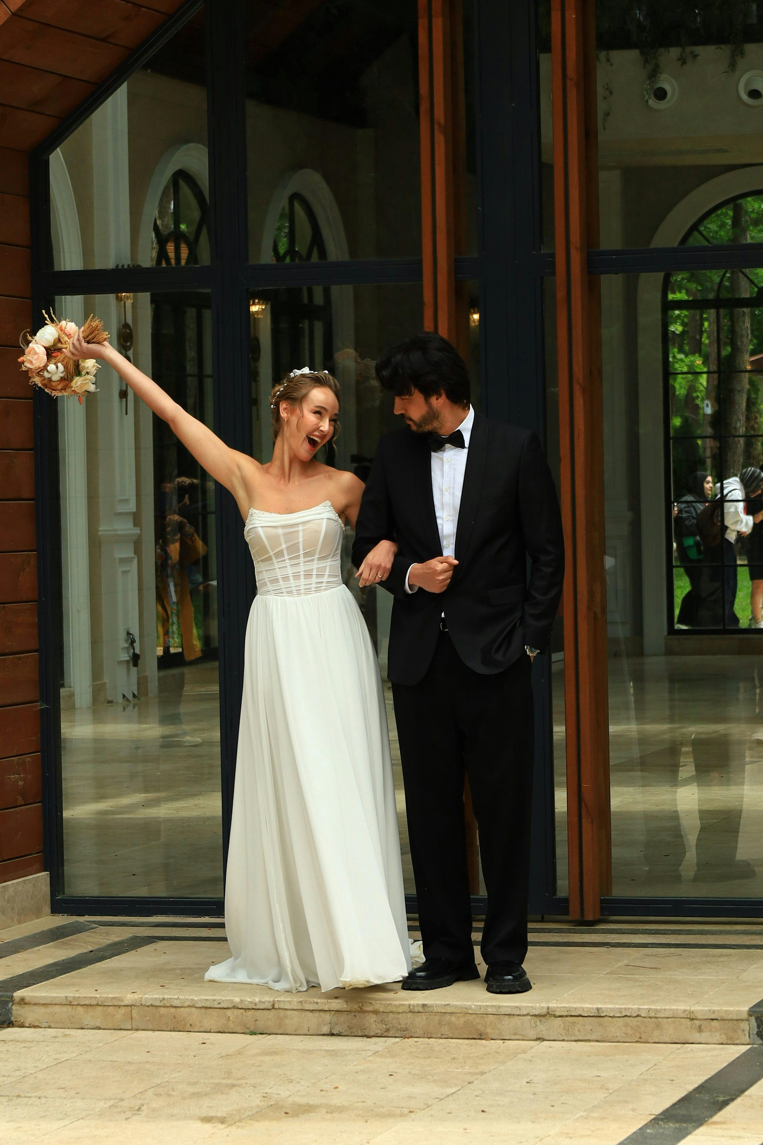 Joyful wedding couple celebrating outside a venue in Istanbul, Türkiye.