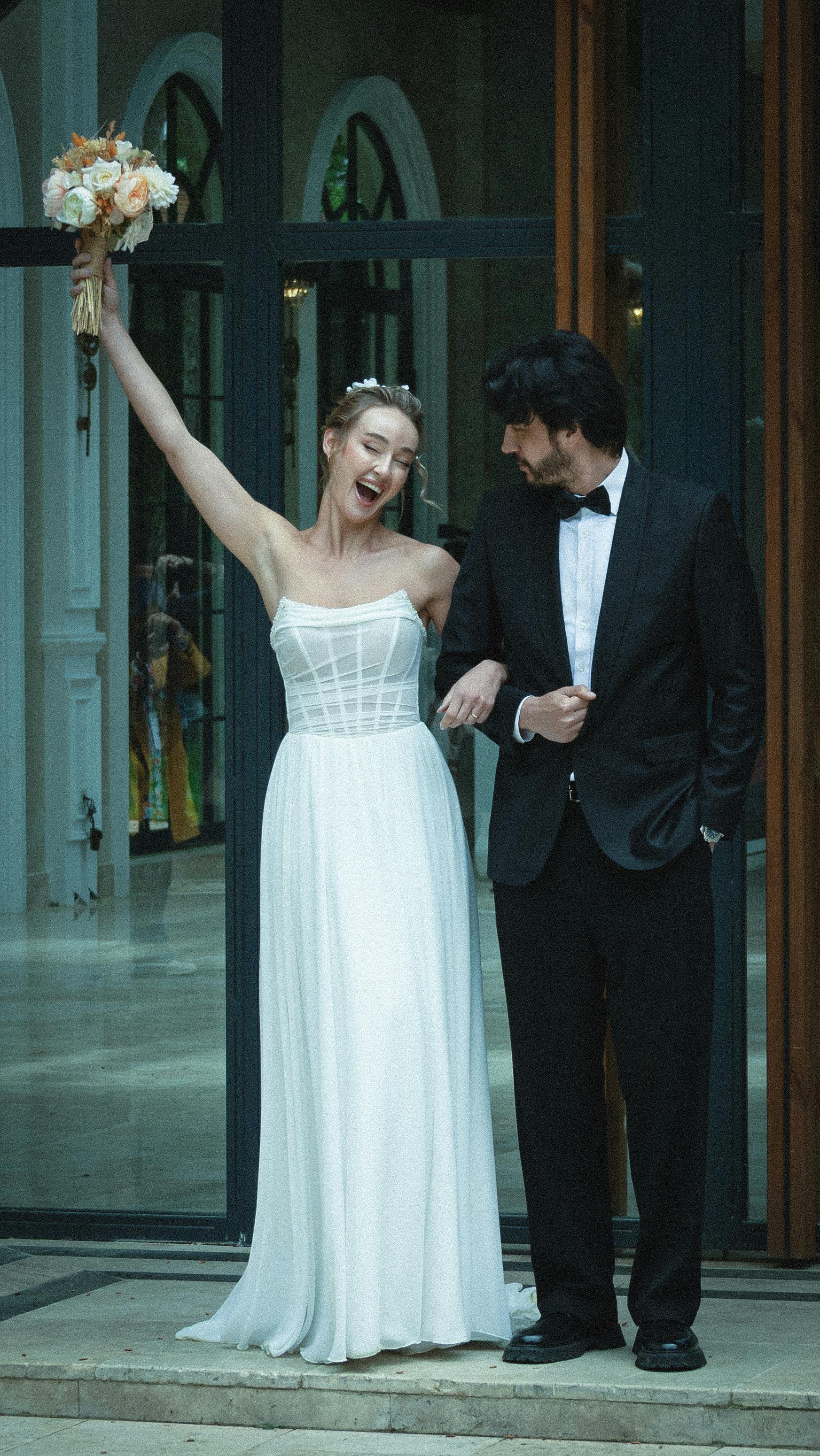 Bride and groom celebrating outside in İstanbul, showcasing pure happiness and love.
