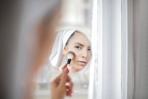 Femme De Culture Faisant Du Maquillage Et Regardant Le Miroir