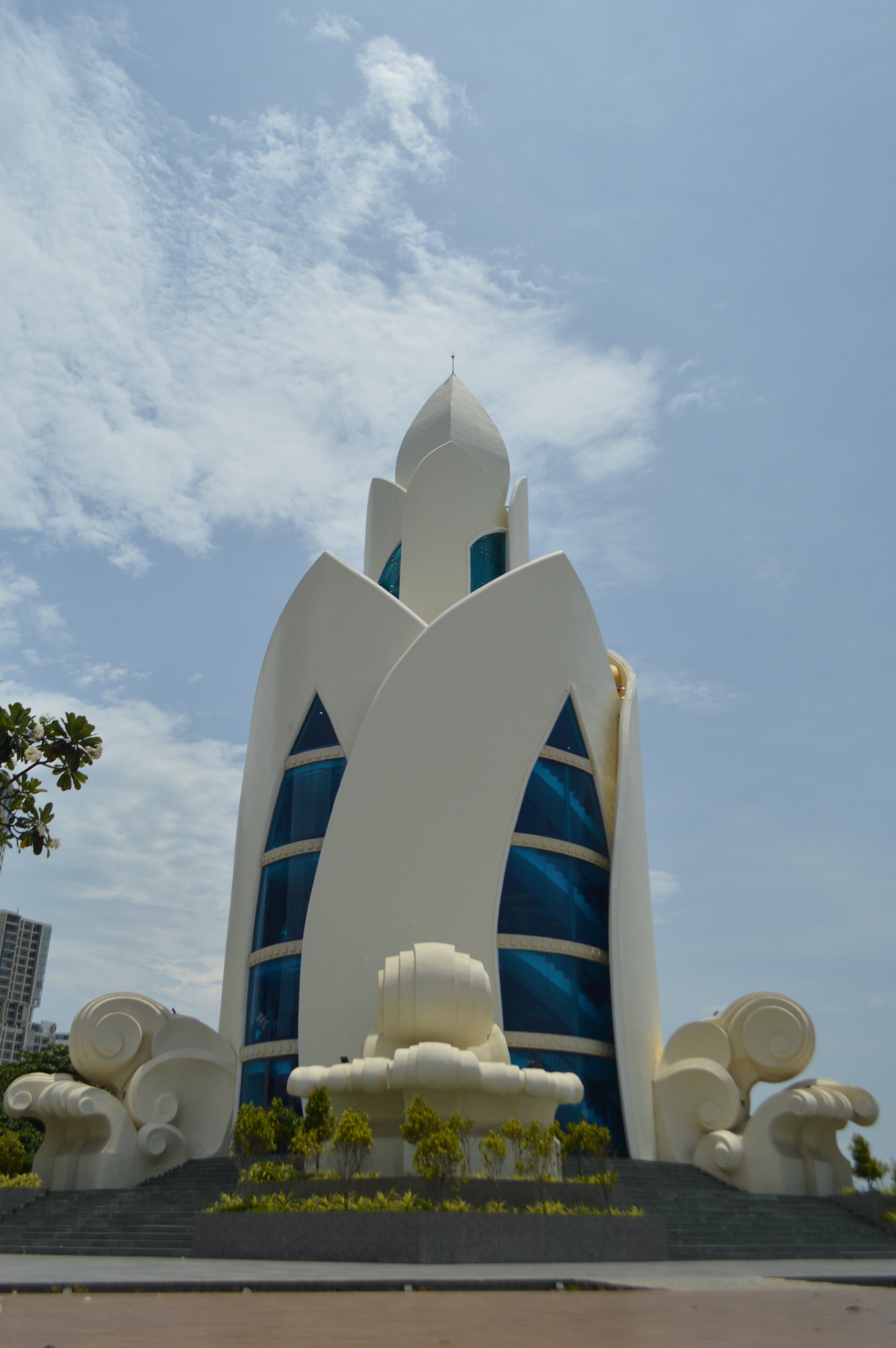 A strikingly futuristic white building with unique design elements against a blue sky.