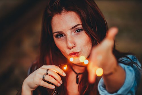 Portrait Photo of Woman Holding Yellow String Lights