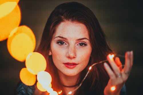 Portrait Photo of Woman Holding Yellow String Lights