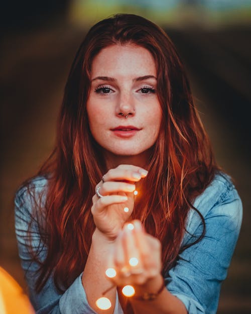 Free Woman in Blue Denim Jacket Holding String Lights Stock Photo