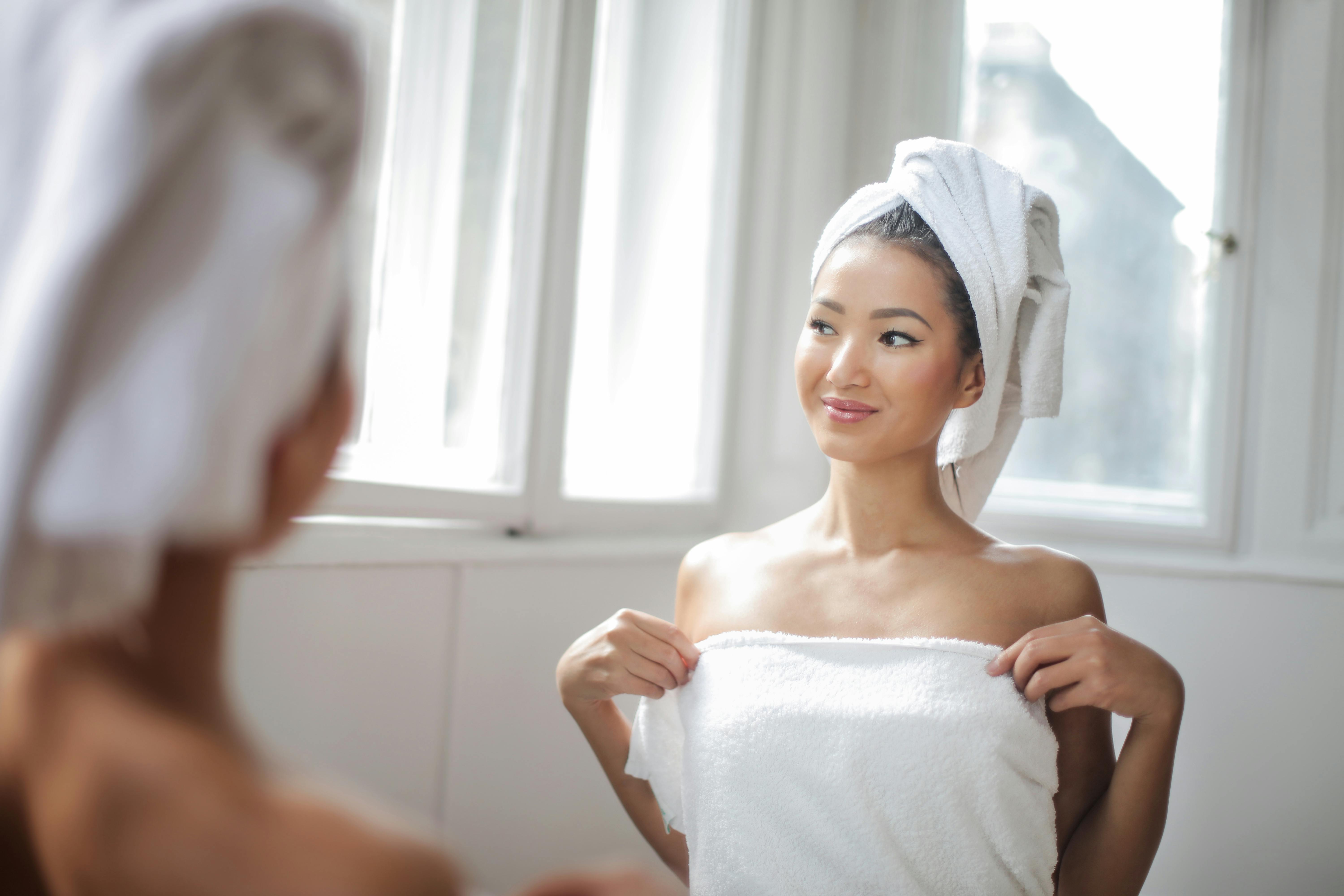 Free Woman in White Towel Standing in Front of the Mirror Stock Photo