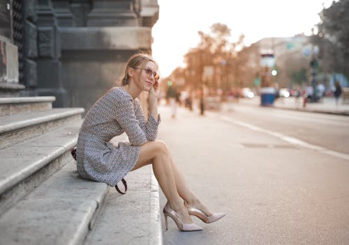 Free Woman in Long Sleeve Dress Sitting on the Stairs Stock Photo