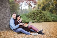 Couple Sitting Near Tree Trunks