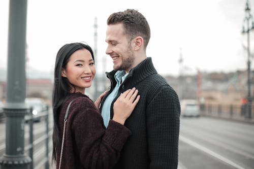Selective Focus Photo of Smiling Couple Standing Next to Each Other