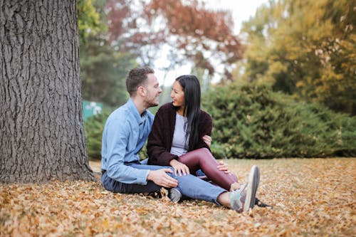 Free Couple Sitting Under The Tree During Daytime Stock Photo