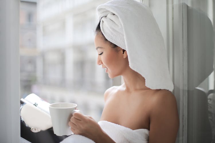 Woman Reading Magazine Near Glass Window