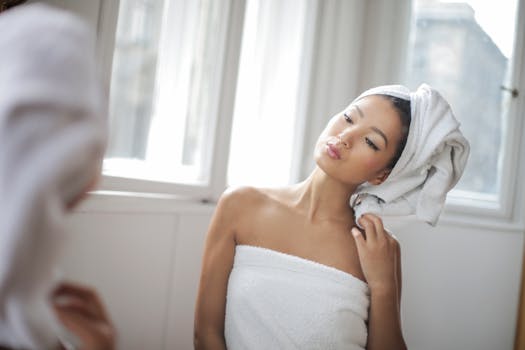 这幅宁静的肖像描绘了一位裹着毛巾的女人，她望着窗外的倒影，捕捉到了放松与美丽