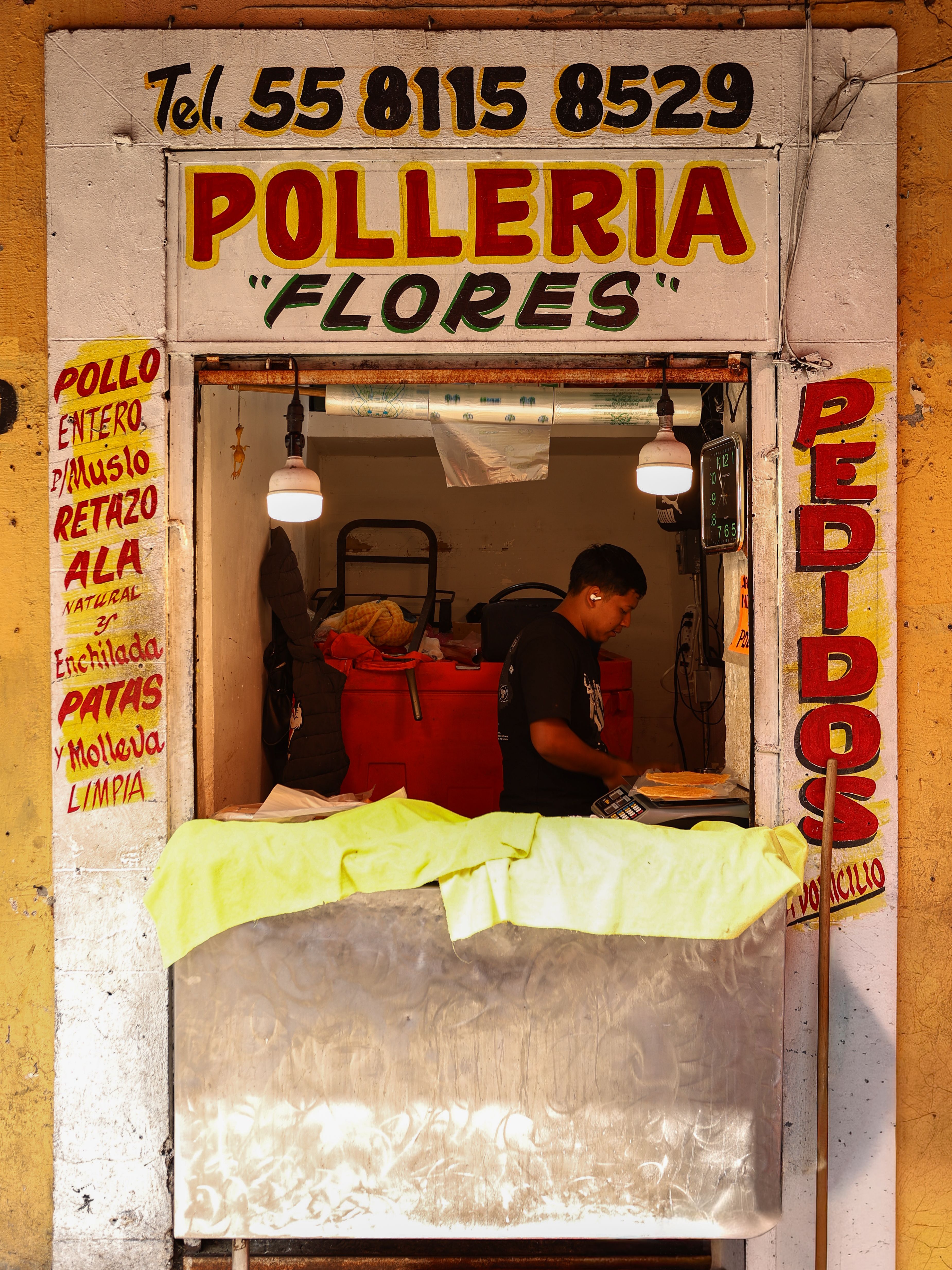 A street view of Polleria Flores in Mexico City, capturing local culture and commerce.