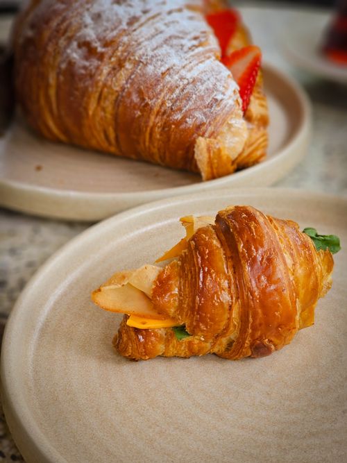 Free Close-up of fresh croissants on plates, garnished with strawberries and lettuce. Stock Photo