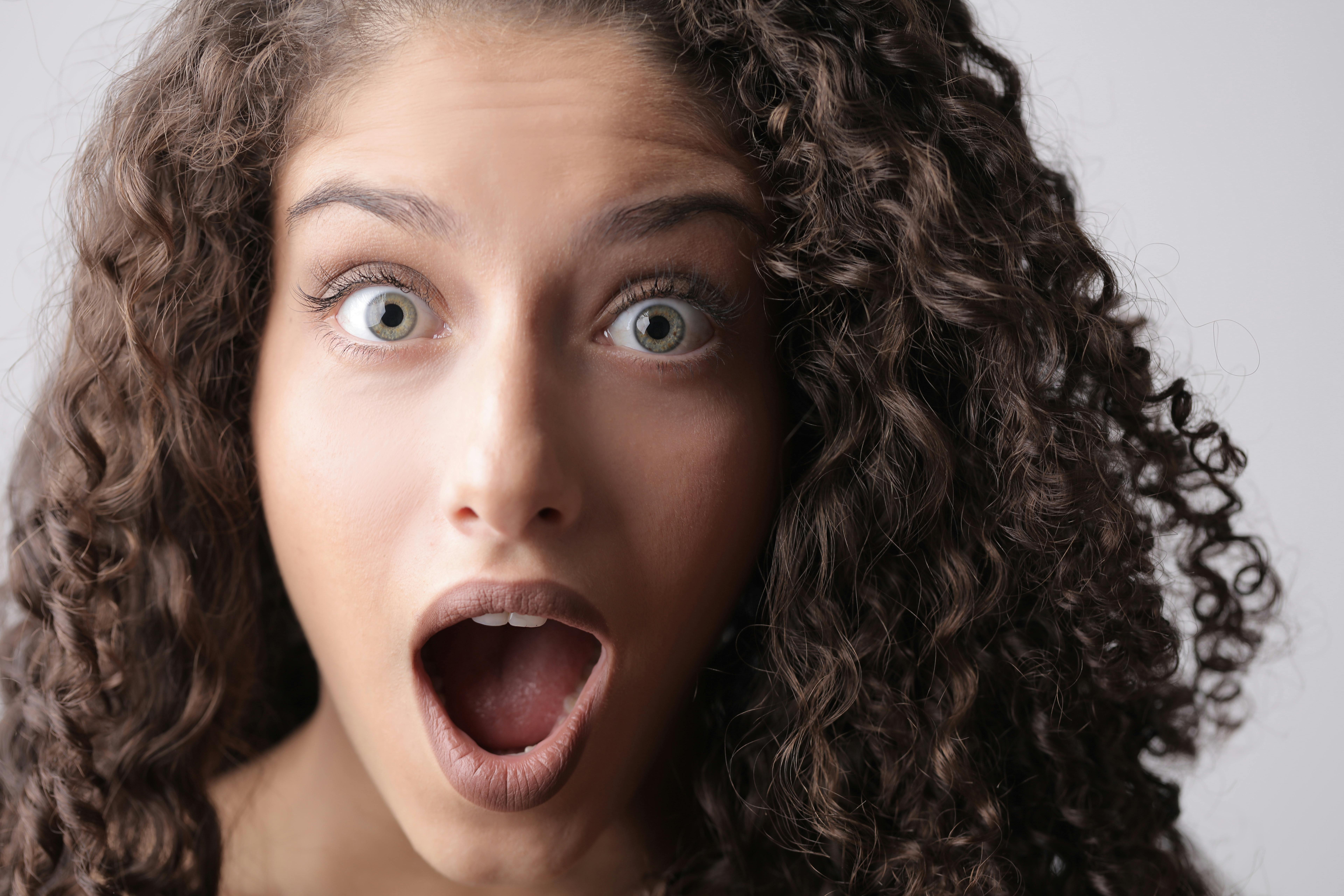 Close Up Photo Of Shocked Woman With Brown Curly Hair Free Stock