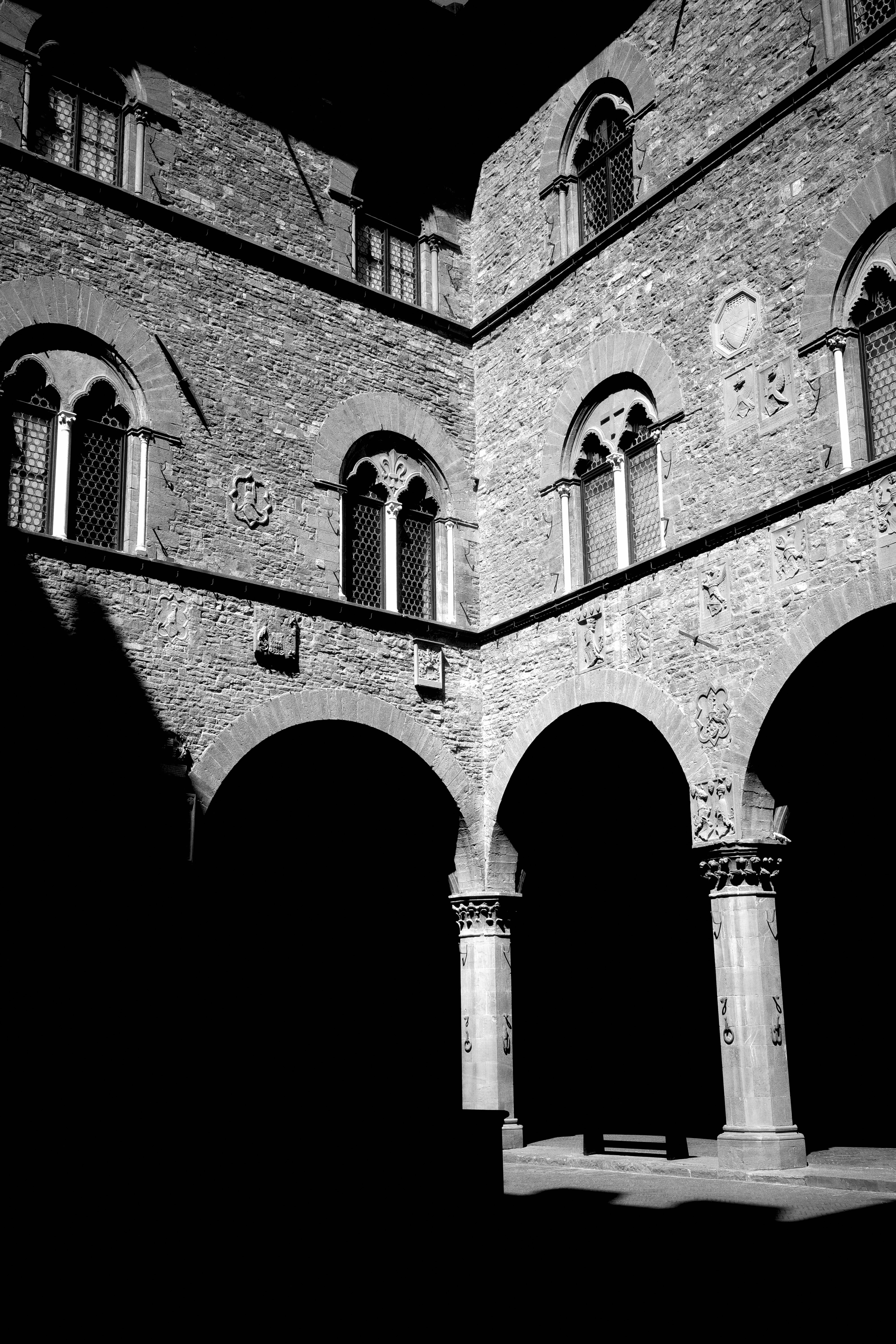 Striking black and white image of historic Italian architecture showcasing arches and shadows.