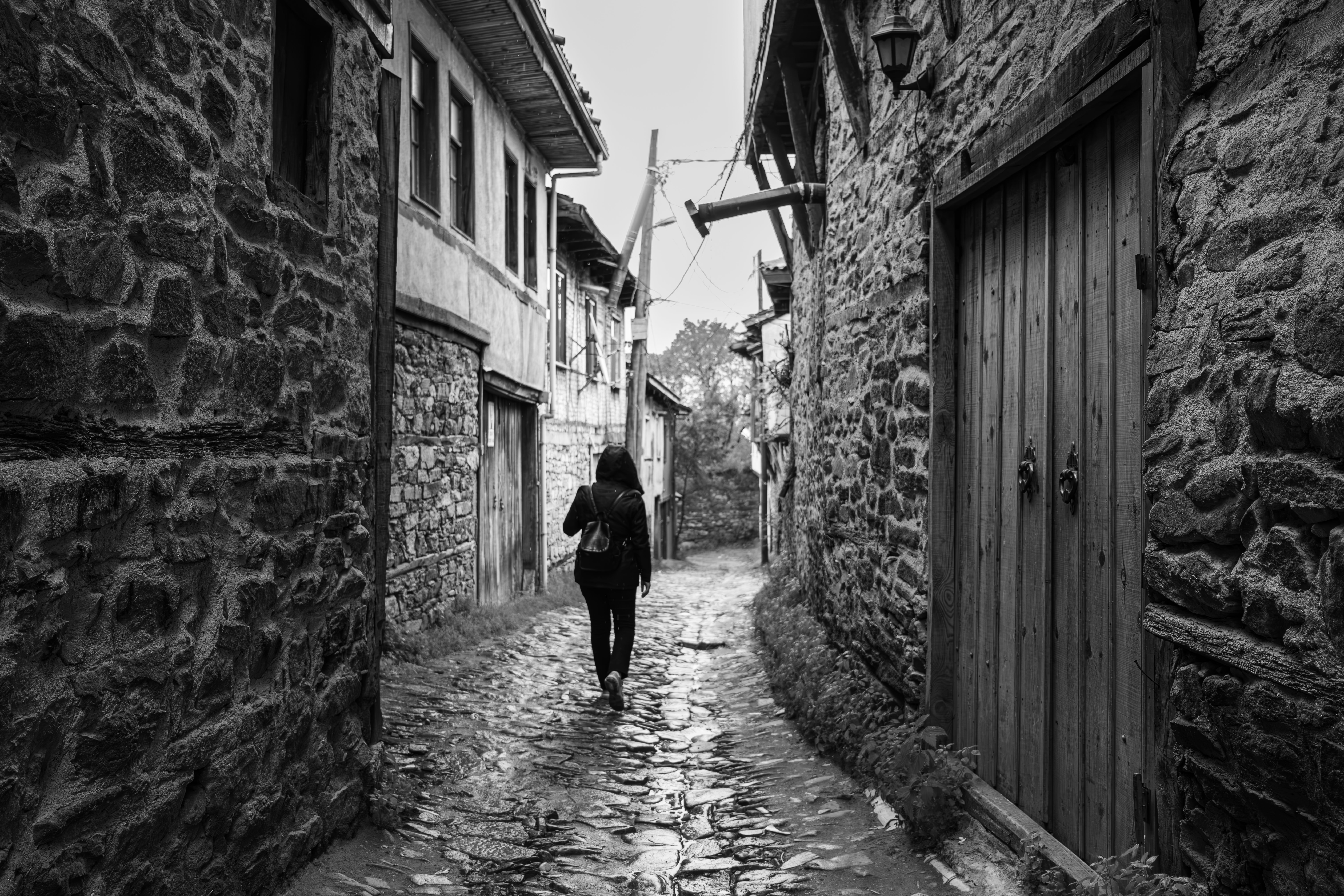 quiet cobblestone village street in the Balkans at sunrise with one local walking