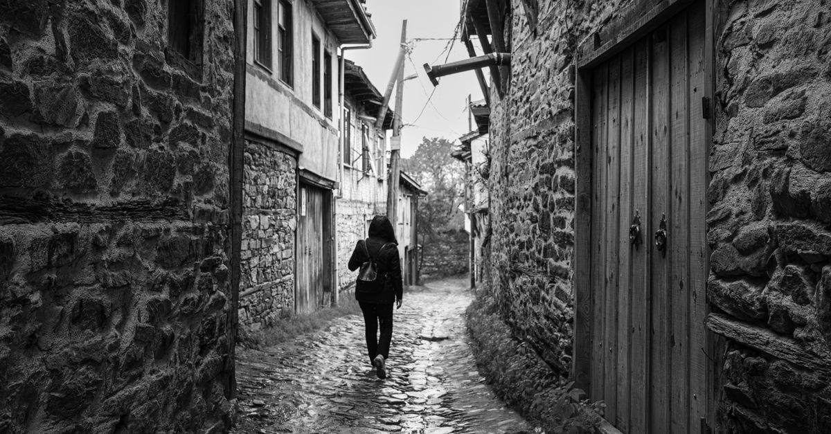 quiet cobblestone village street in the Balkans at sunrise with one local walking