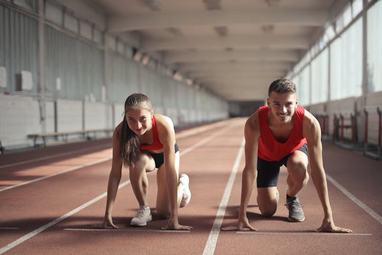 Men And Woman In Red Tank Top Is Ready To Run On Track Field