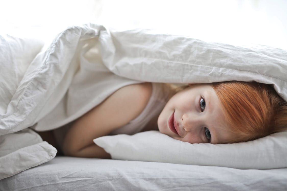 Free Photo of Young Girl Lying in White Bed Stock Photo