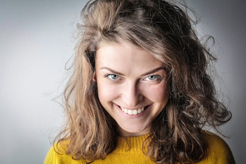 Free Portrait Photo of Smiling Woman in Yellow Sweater Stock Photo