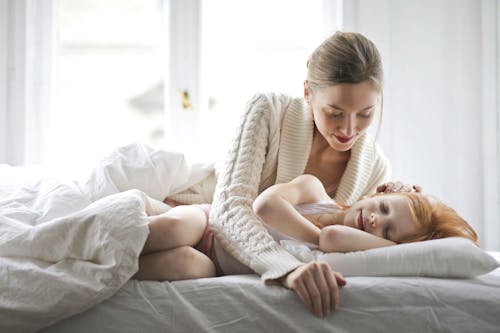 Free Mother and child resting on bed Stock Photo