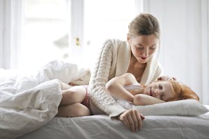 Mother and child resting on bed