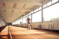 穿着运动服的女子在室内跑道上跑步，展现了速度与决心