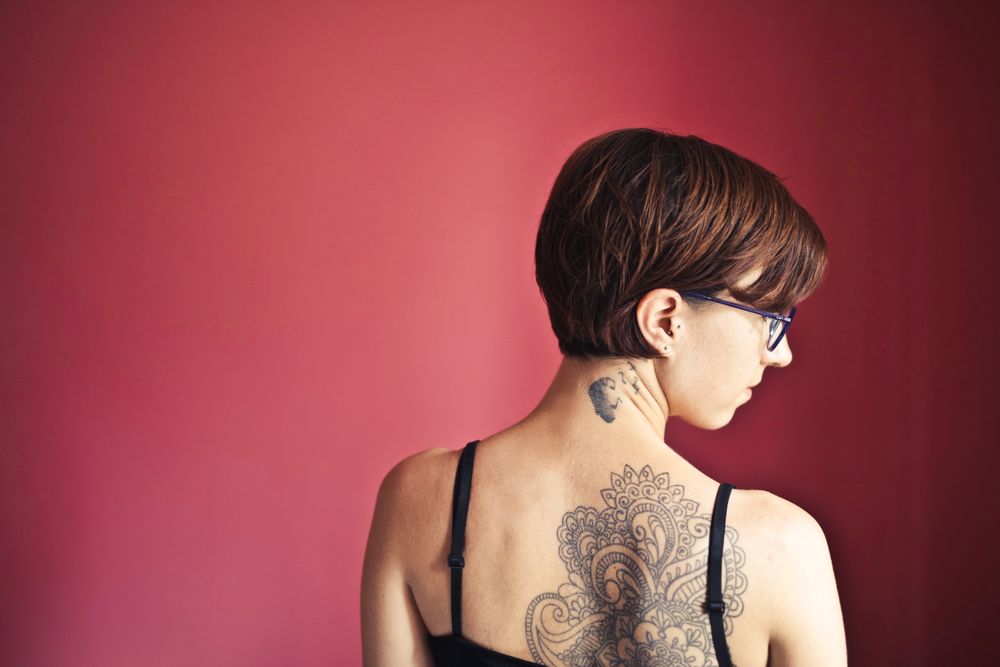Client showing a healed floral back tattoo