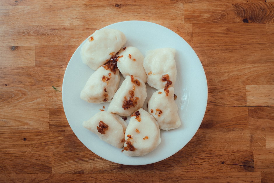 A plate of traditional Lithuanian Cepelinai (potato dumplings) served in a restaurant