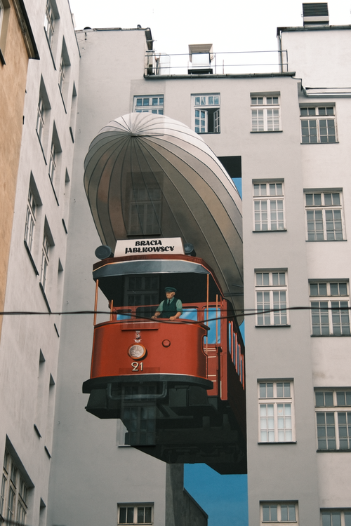 Free Captivating mural of a red tram integrated into building architecture in Warsaw. Stock Photo