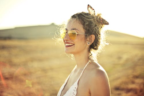 gratis Selectieve Aandacht Zijaanzicht Foto Van Glimlachende Vrouw In Witte Bovenkleding Met Vliegenierszonnebril Stockfoto