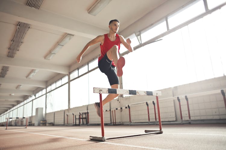 Strong Young Sportsman Jumping Over Barrier