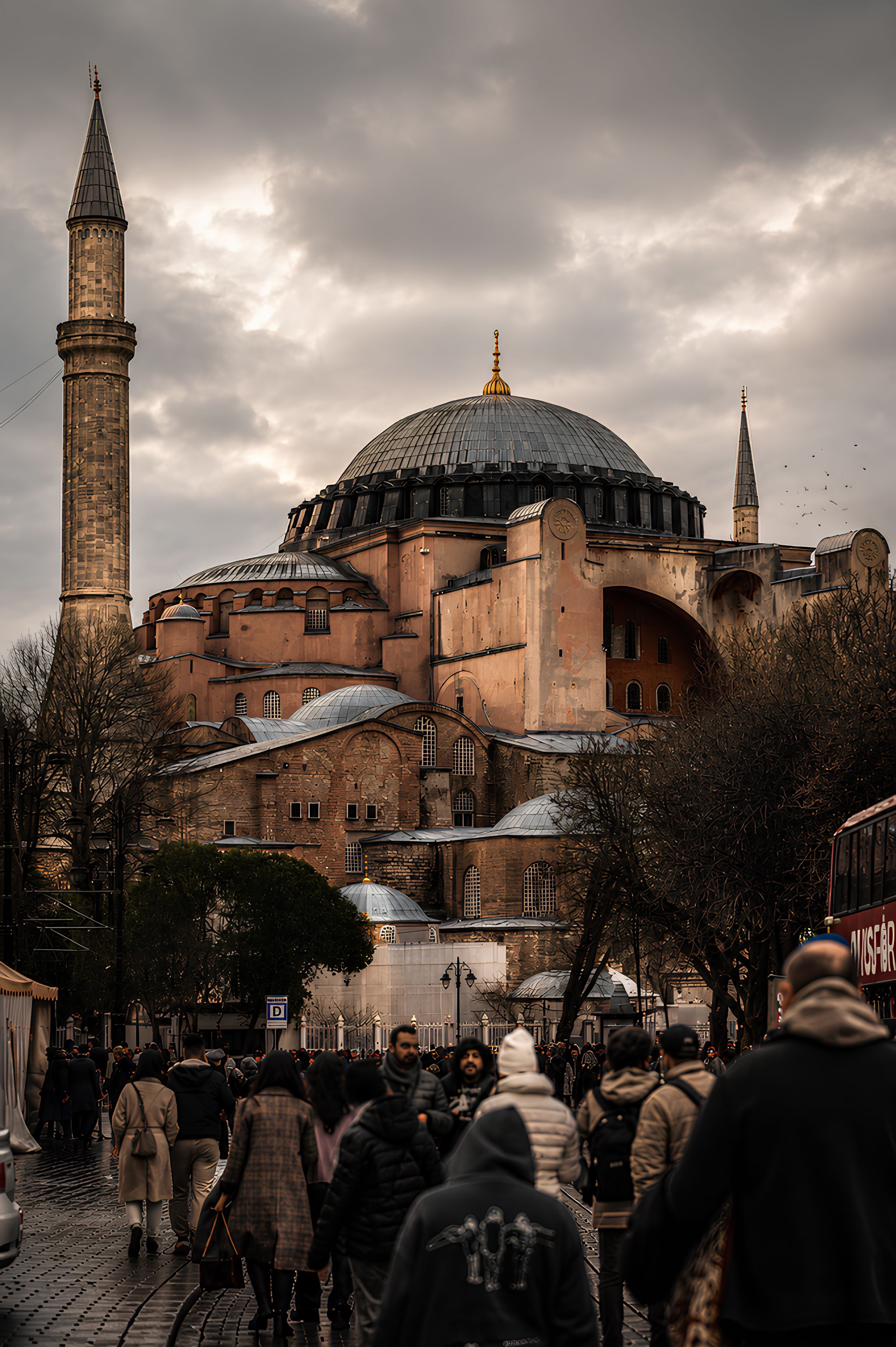 Crowds walk towards the historic Hagia Sophia under a dramatic sky, highlighting its iconic architecture.
