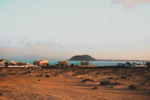 Free Vibrant coastal landscape with distant hills under a clear sky, suitable for travel and nature themes. Stock Photo