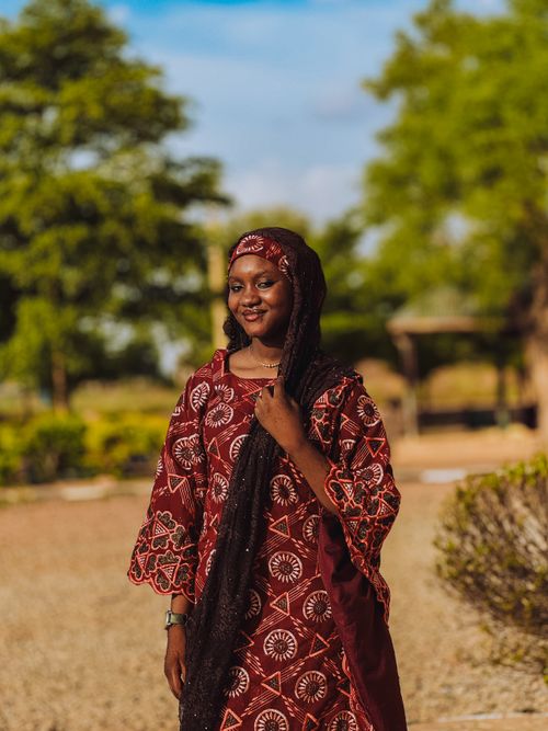 Free Young woman in traditional attire enjoying a sunny day outdoors amidst lush greenery. Stock Photo