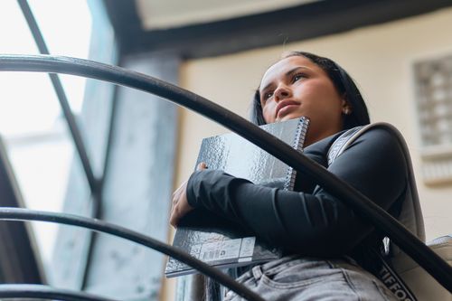 Free Woman holding a notebook, standing indoors with a thoughtful expression, Uruguay. Stock Photo