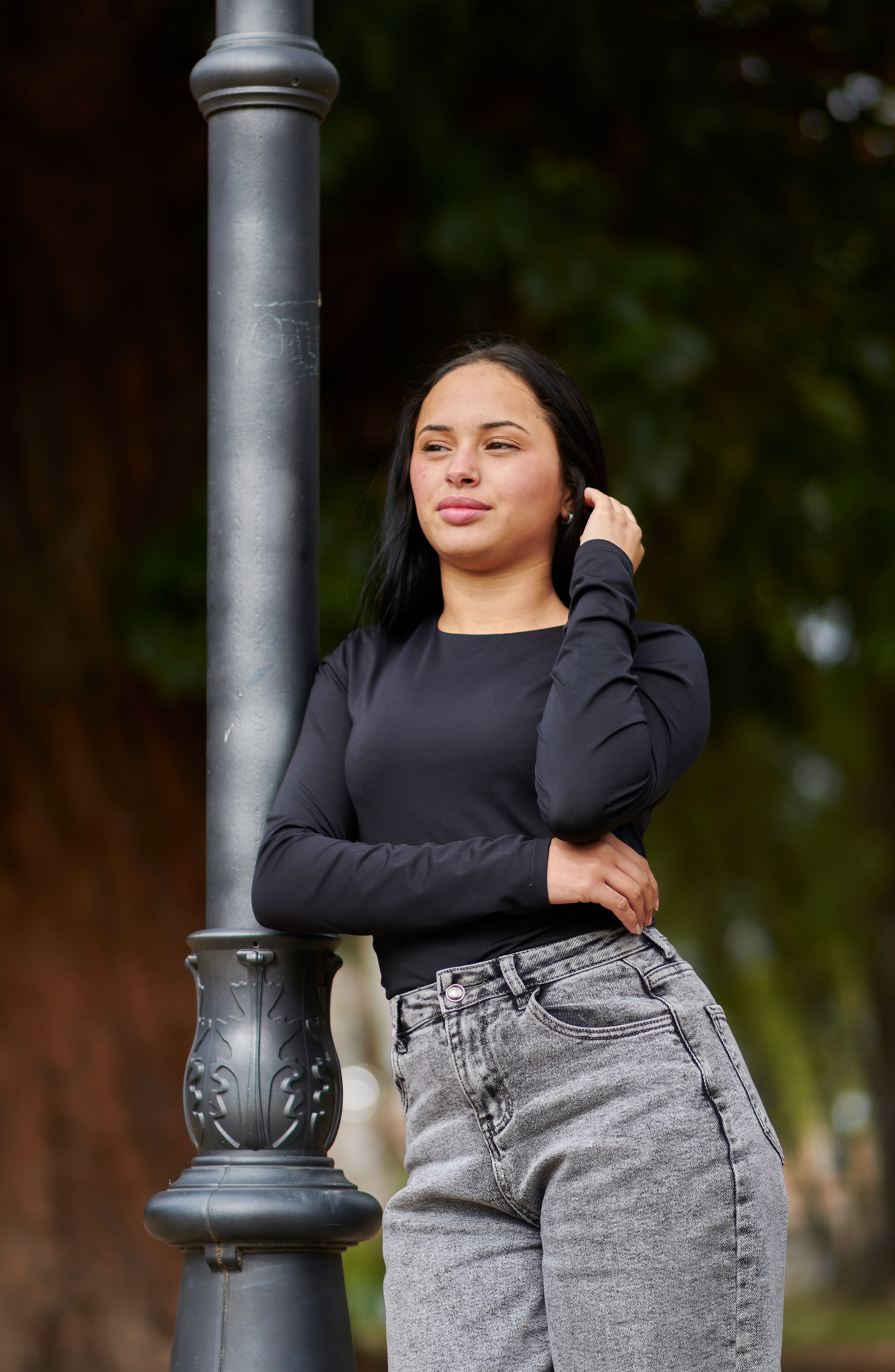 young-woman-posing-by-lamp-post-outdoors-free-stock-photo