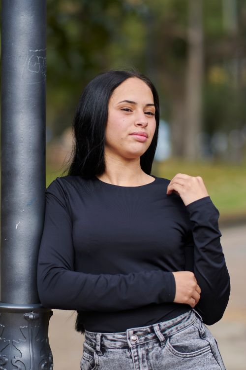 Free Casual outdoor portrait of a woman standing by a lamppost in an urban park in Uruguay. Stock Photo