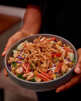 Delicious chicken salad with crispy tortilla strips and fresh veggies in a bowl.