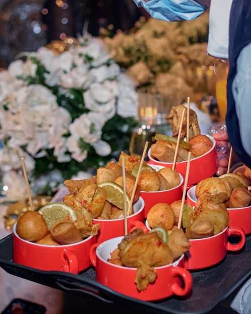 Free Platter of assorted fried snacks with lemons, set against a floral backdrop. Stock Photo