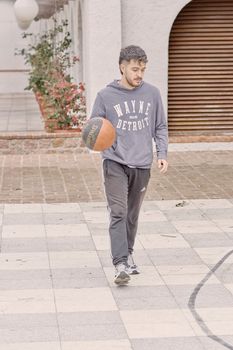 Casual urban basketball game in Uruguay featuring a young adult male dribbling.