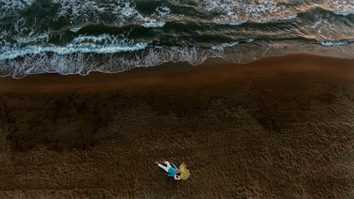 Aerial Photo of  Couple Lying On seashore