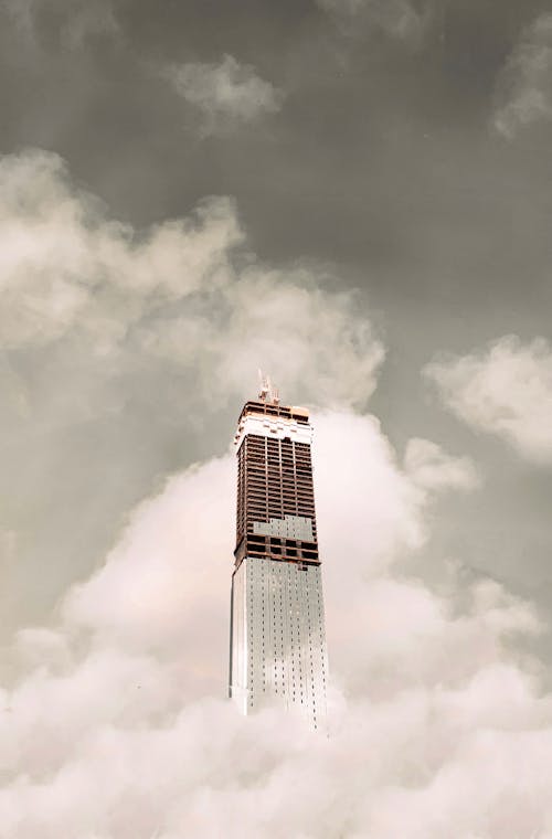 Futuristic tall skyscraper against cloudy sky