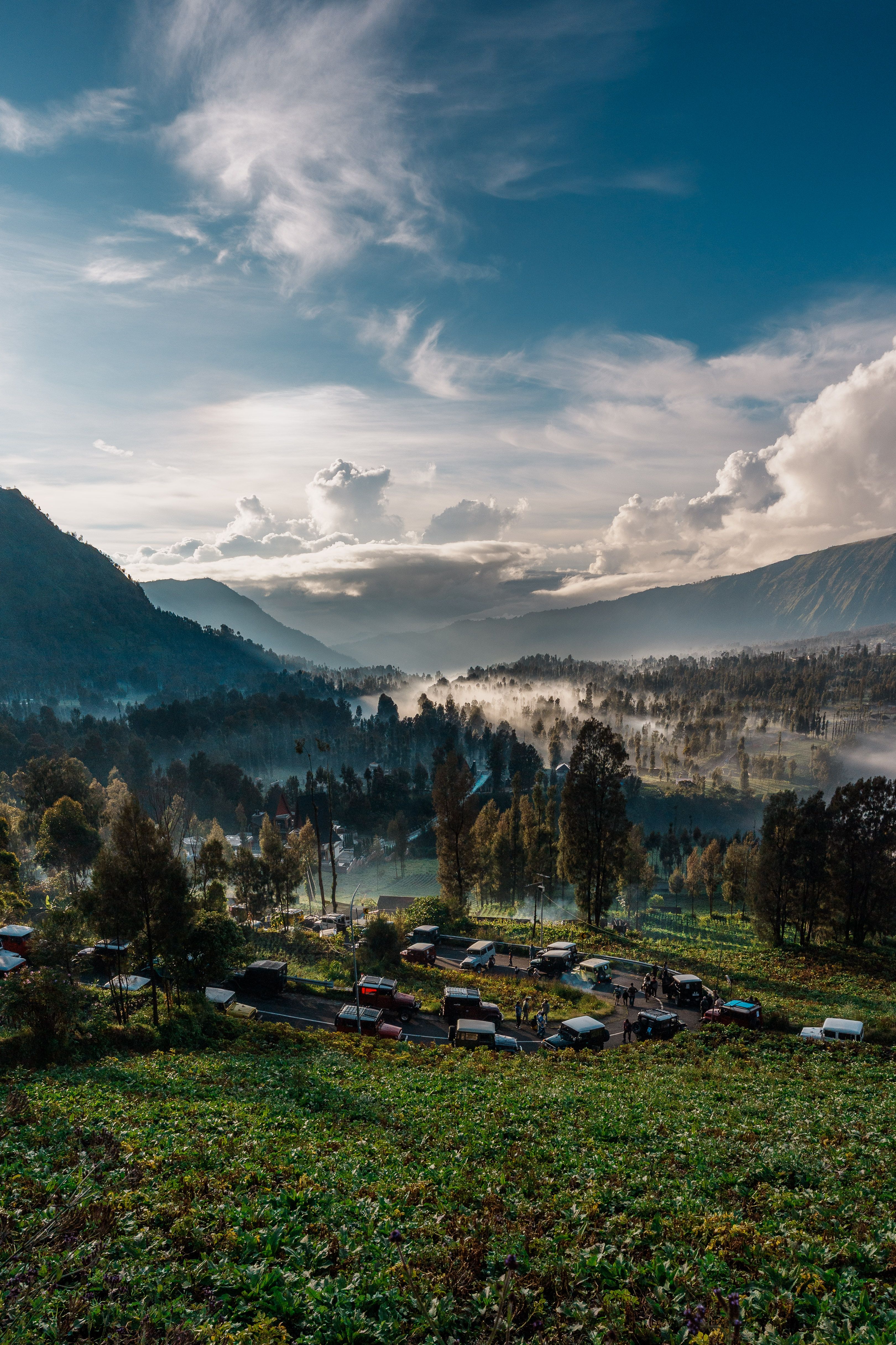Fotomural Impresionante paisaje de un valle brumoso rodeado de montañas en Java Oriental, Indonesia.